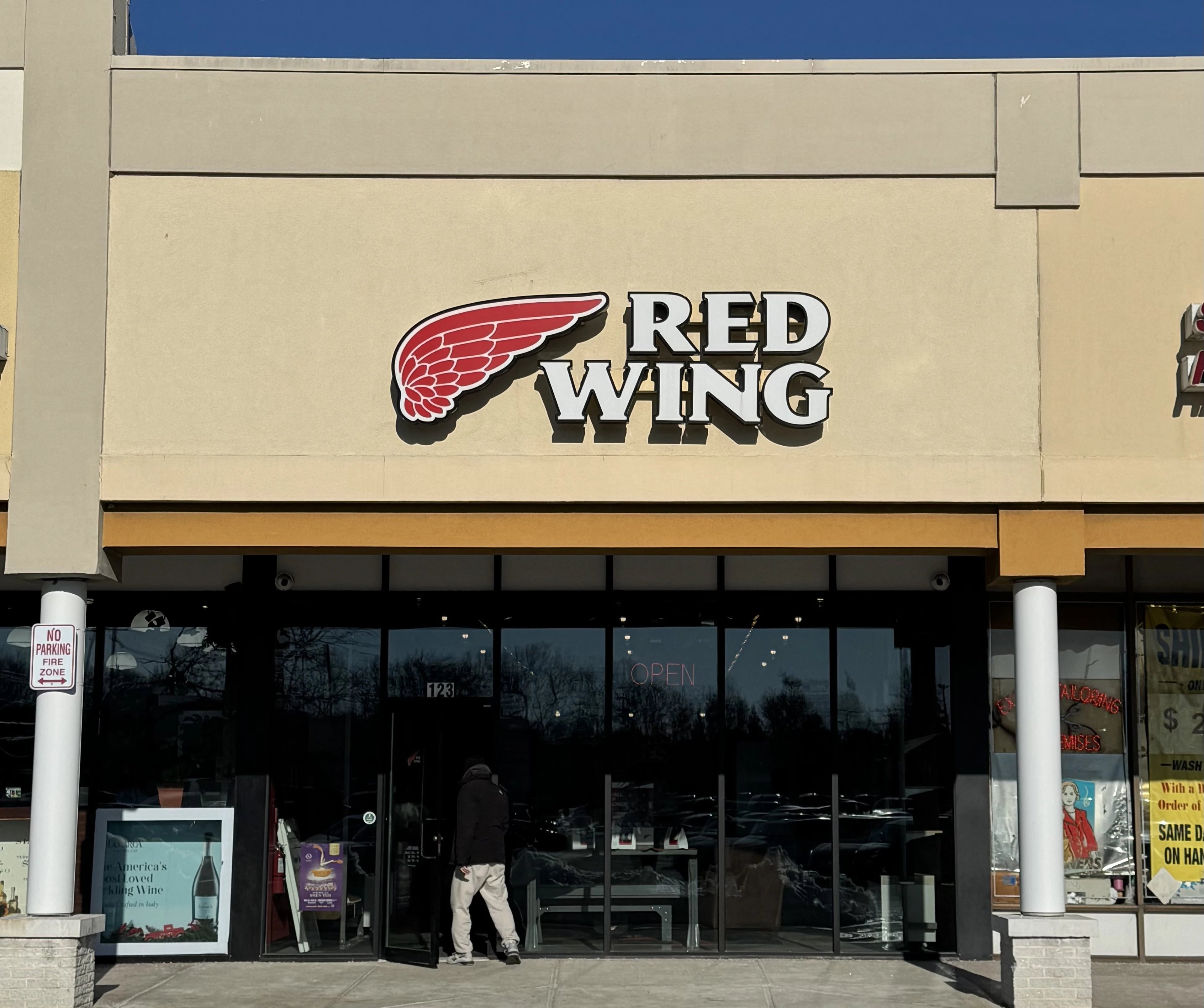 Red Wing store front with logo on a clear day