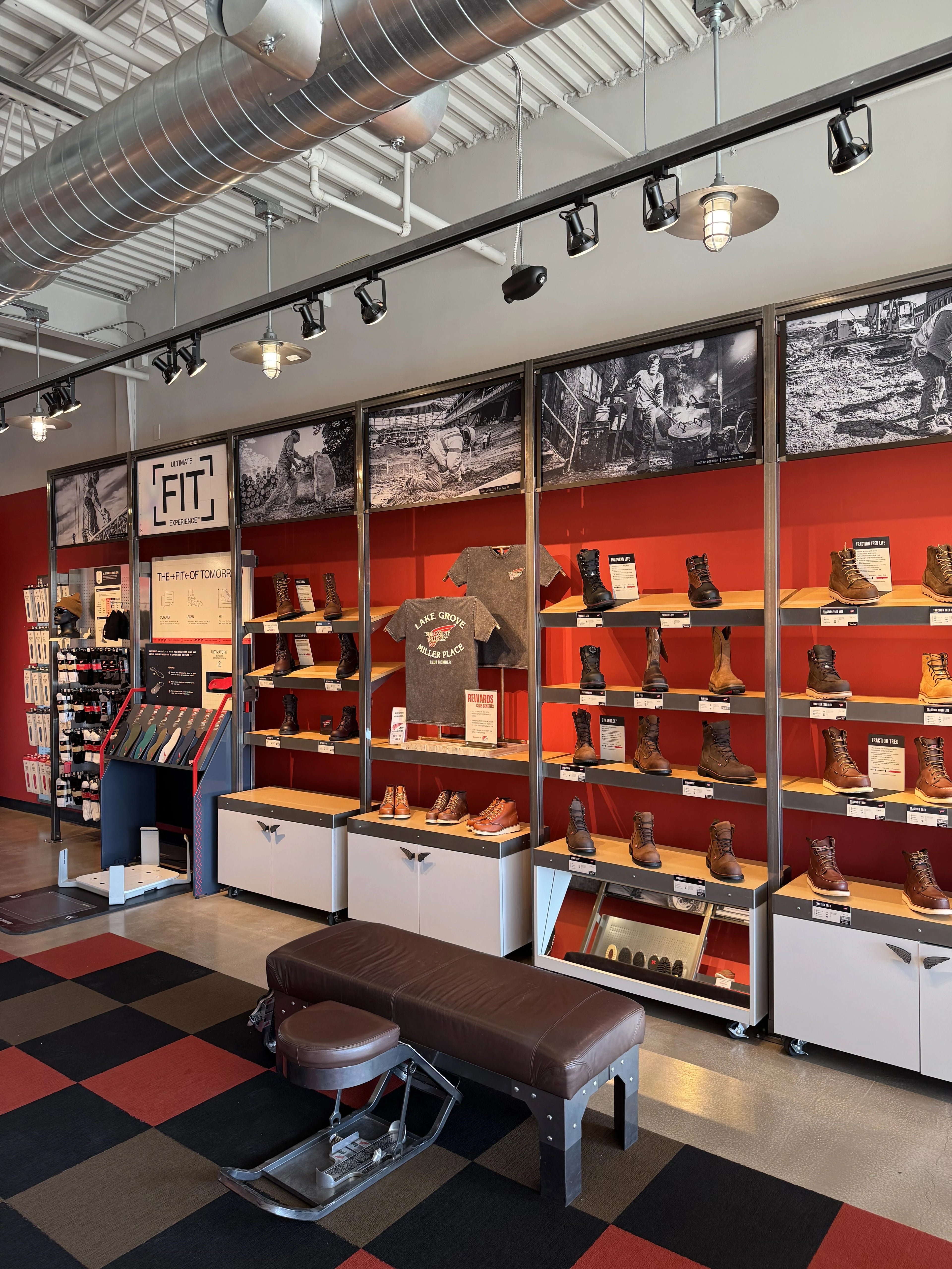 Shoe display with red and black patterned wall and ceiling lights.